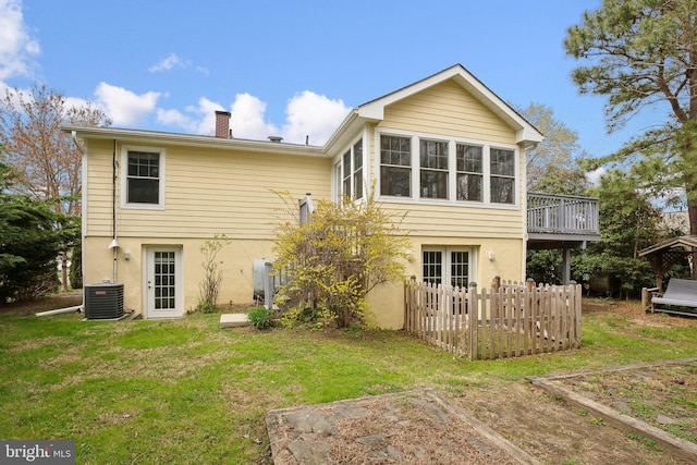 back of property featuring stucco siding, french doors, central AC, and a yard