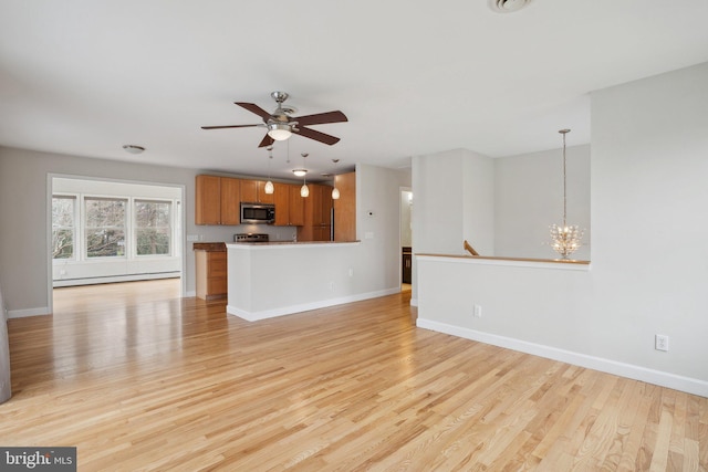 unfurnished living room with light wood-type flooring, a baseboard radiator, baseboards, and ceiling fan with notable chandelier
