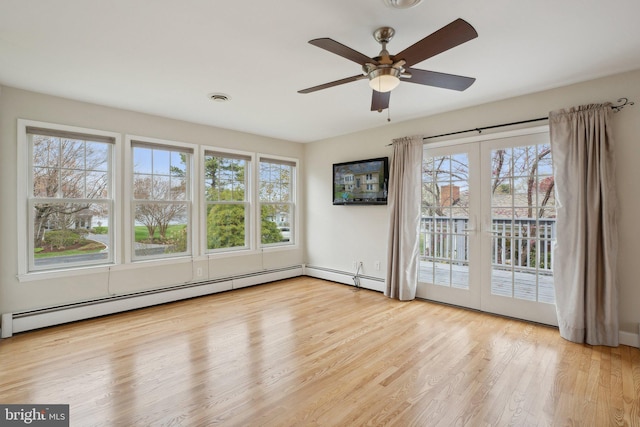 empty room featuring ceiling fan, wood finished floors, and a wealth of natural light
