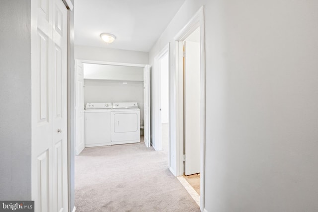 corridor featuring light colored carpet and washer and clothes dryer