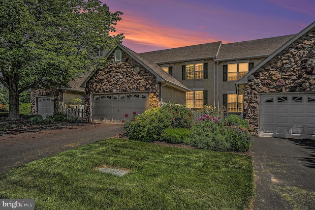 front facade with a yard and a garage