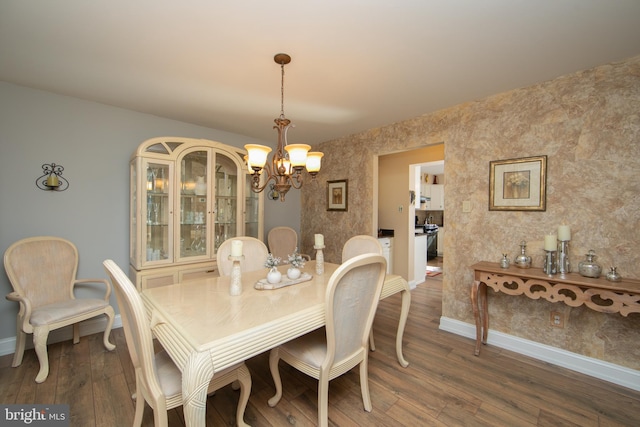 dining room featuring dark wood-type flooring and a chandelier