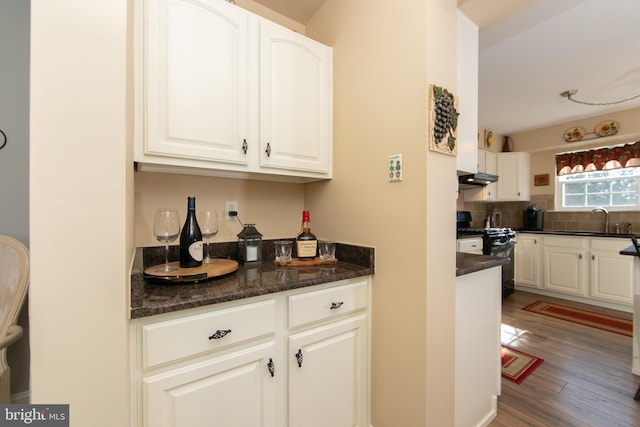 kitchen with black gas range oven, sink, and white cabinetry