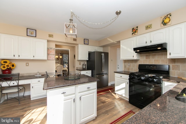 kitchen with white cabinetry, hanging light fixtures, a center island, black appliances, and light wood-type flooring