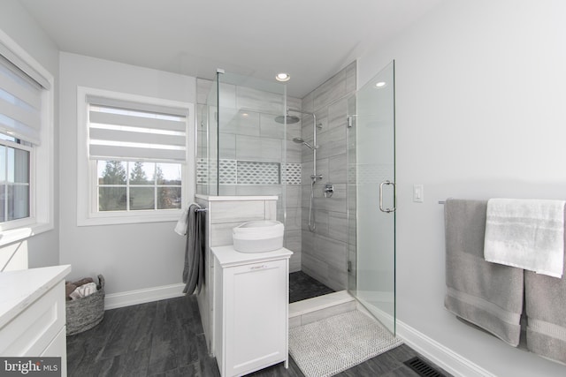 bathroom featuring a shower with door, vanity, and hardwood / wood-style flooring