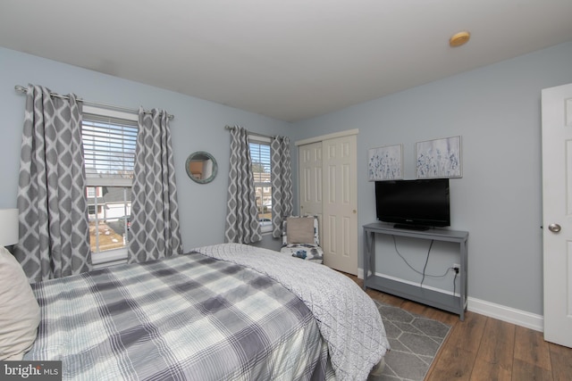 bedroom with dark wood-type flooring and a closet