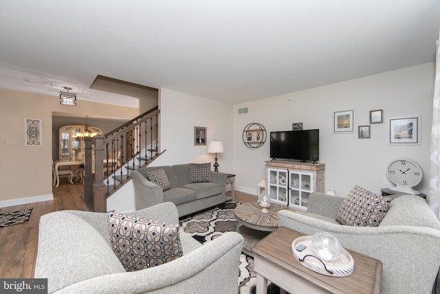 living room with hardwood / wood-style flooring and an inviting chandelier