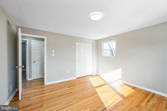 unfurnished bedroom with a closet and light hardwood / wood-style flooring