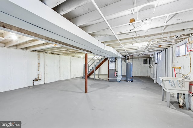 basement featuring heating unit, sink, and water heater