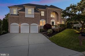 view of front of property with a front lawn, concrete driveway, and an attached garage