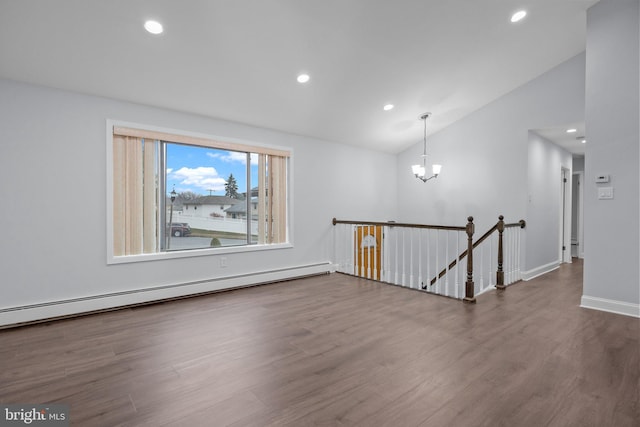 empty room featuring baseboard heating, a notable chandelier, lofted ceiling, and hardwood / wood-style flooring