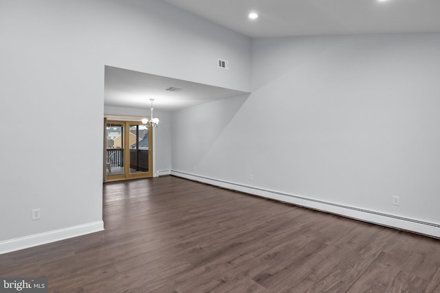 spare room featuring an inviting chandelier, baseboard heating, vaulted ceiling, and dark wood-type flooring