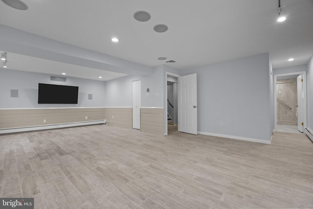 unfurnished living room featuring light wood-type flooring and baseboard heating