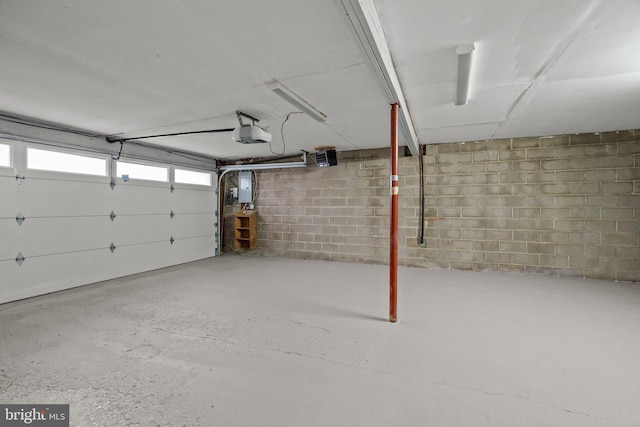 garage with a garage door opener and electric panel