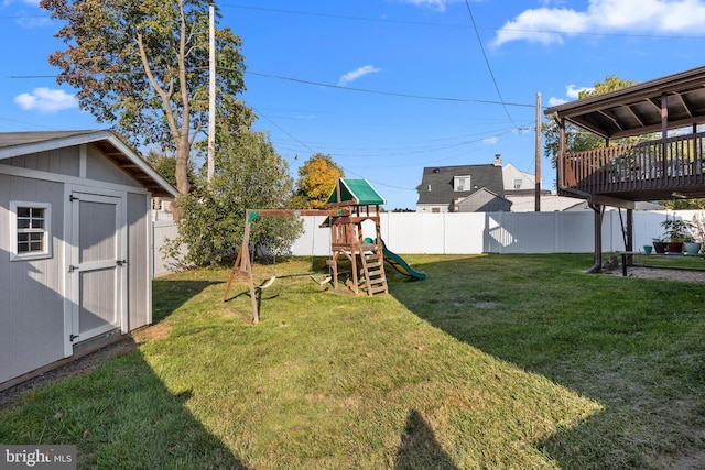 view of yard with a storage shed, a playground, and a deck