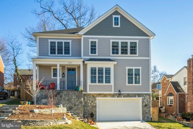 view of front facade featuring an attached garage, stone siding, a porch, and concrete driveway