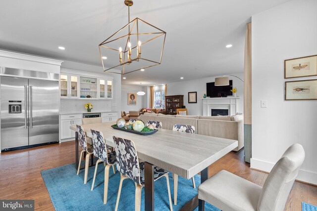 dining room with recessed lighting, dark wood-style flooring, a fireplace, visible vents, and baseboards