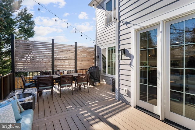 deck featuring outdoor dining space and area for grilling