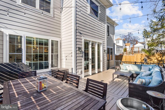 wooden terrace with outdoor lounge area, fence, and outdoor dining area