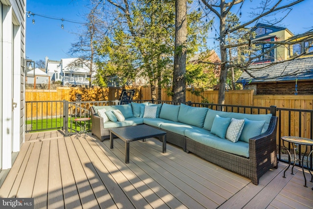 wooden terrace with a fenced backyard and an outdoor living space