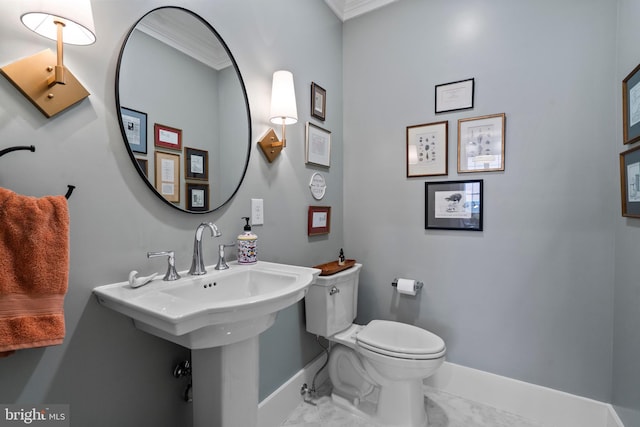 half bathroom with marble finish floor, ornamental molding, toilet, and baseboards