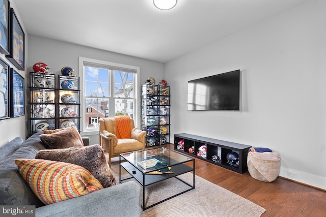 living area with baseboards and wood finished floors