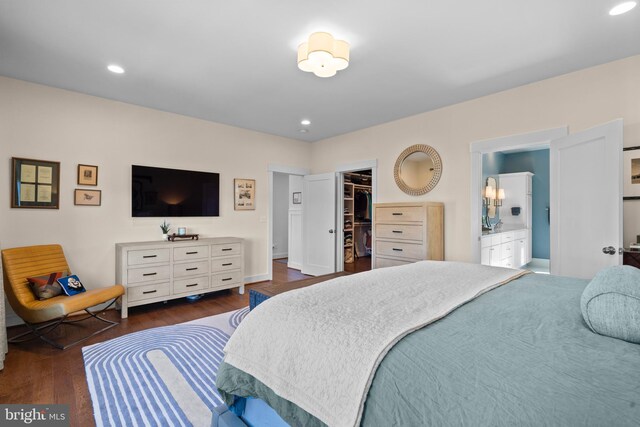 bedroom featuring dark wood-style floors, a walk in closet, recessed lighting, a closet, and ensuite bathroom