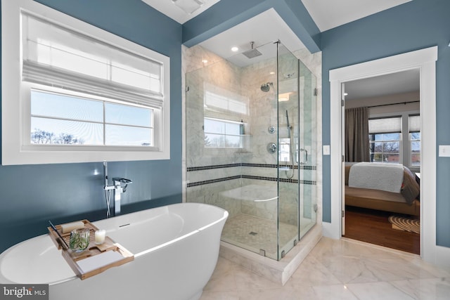 ensuite bathroom featuring a freestanding bath, marble finish floor, a shower stall, and ensuite bathroom