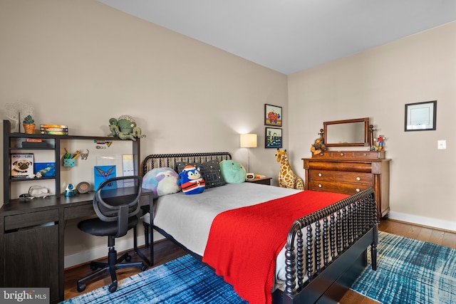 bedroom featuring wood finished floors and baseboards