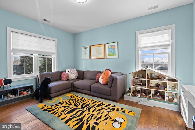 living area featuring wood finished floors and visible vents