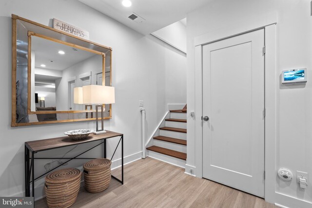 foyer entrance with recessed lighting, visible vents, stairway, wood finished floors, and baseboards