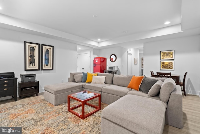 living area with light wood-style floors, baseboards, and recessed lighting