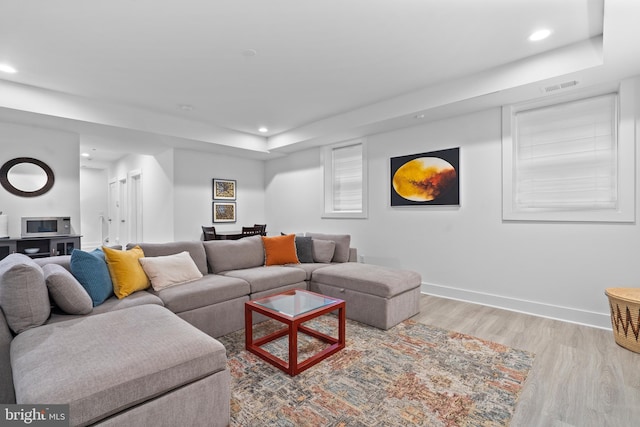 living area featuring recessed lighting, visible vents, baseboards, and wood finished floors