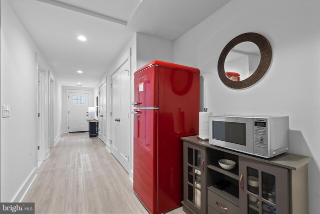 corridor with baseboards, wood finished floors, and recessed lighting