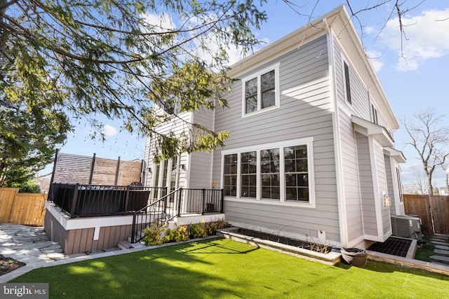 back of house with a yard, fence, a wooden deck, and central AC unit