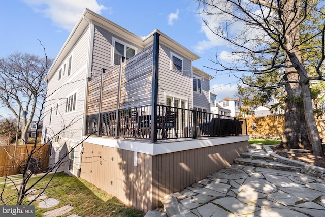 rear view of property featuring fence