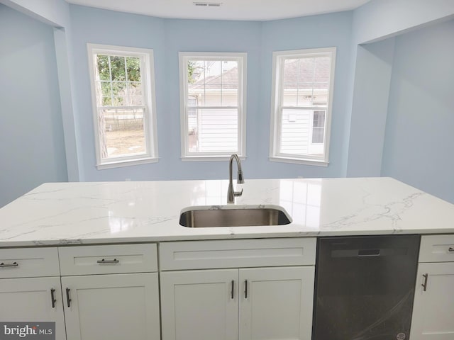 kitchen featuring white cabinetry, dishwasher, light stone counters, and sink