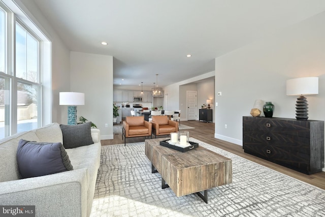 living room with light wood-style flooring, baseboards, and recessed lighting