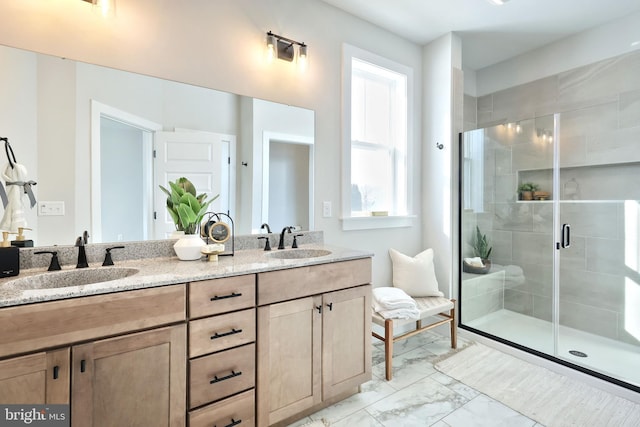 full bath featuring a stall shower, marble finish floor, a sink, and double vanity