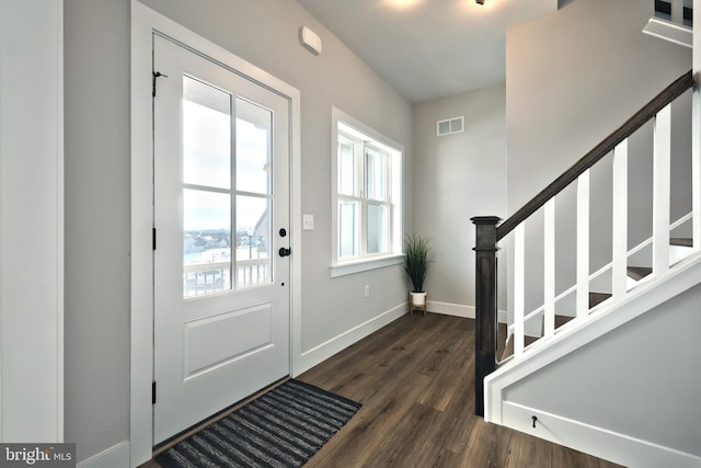 doorway to outside featuring visible vents, dark wood finished floors, stairway, and baseboards