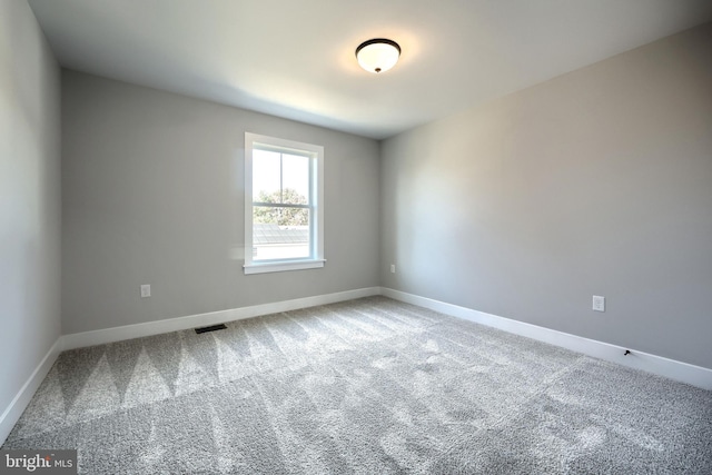 carpeted empty room with baseboards and visible vents