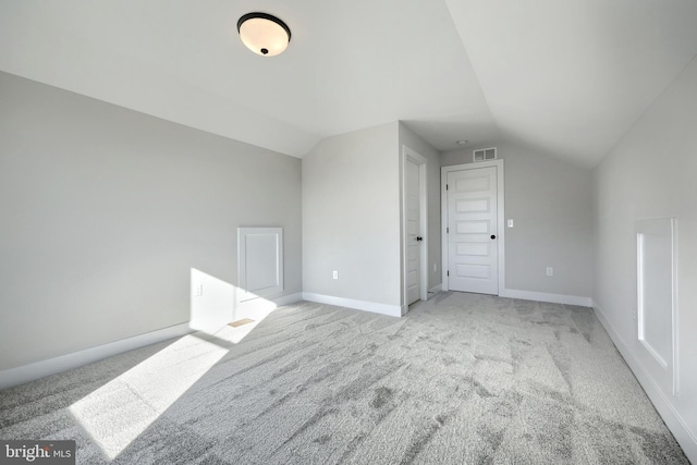 bonus room with lofted ceiling, baseboards, visible vents, and light colored carpet