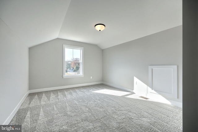 bonus room featuring light carpet, vaulted ceiling, visible vents, and baseboards