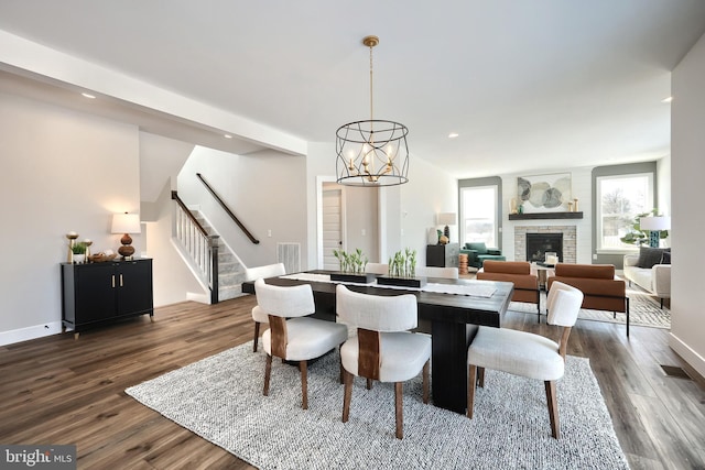 dining space featuring stairs, dark wood-type flooring, a fireplace, and visible vents