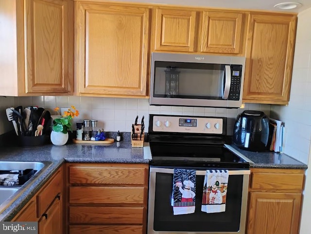 kitchen featuring stainless steel appliances, sink, and backsplash