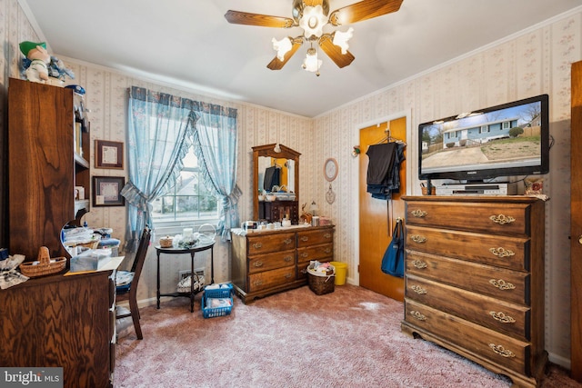 carpeted bedroom with ornamental molding, ceiling fan, and wallpapered walls