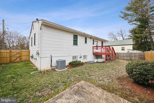 back of property with a yard, a fenced backyard, a gate, and central air condition unit