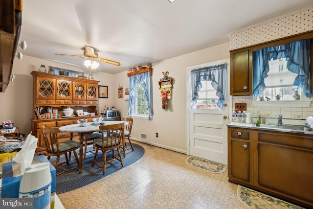 dining room with light floors, visible vents, ceiling fan, and baseboards