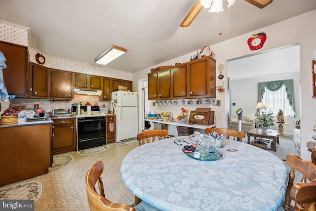 kitchen featuring electric range, decorative backsplash, ceiling fan, freestanding refrigerator, and under cabinet range hood