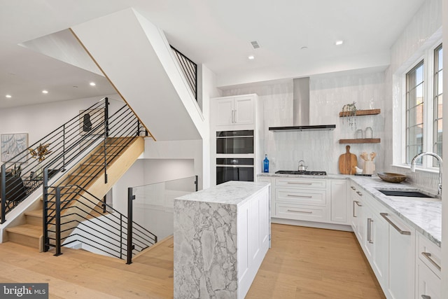 1106 Cypress St, Philadelphia, PA 19107 - kitchen featuring wall chimney range hood, a sink, open shelves, light wood-type flooring, and stainless steel gas cooktop